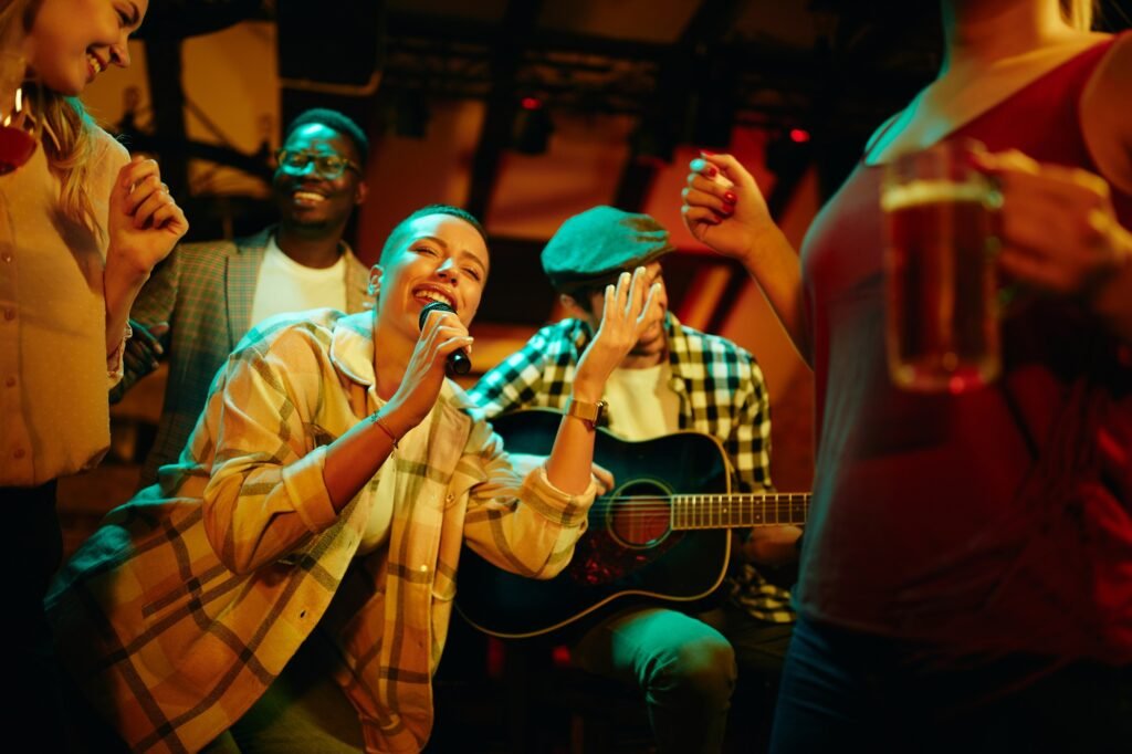 Happy African American woman signing during a night party at the pub.