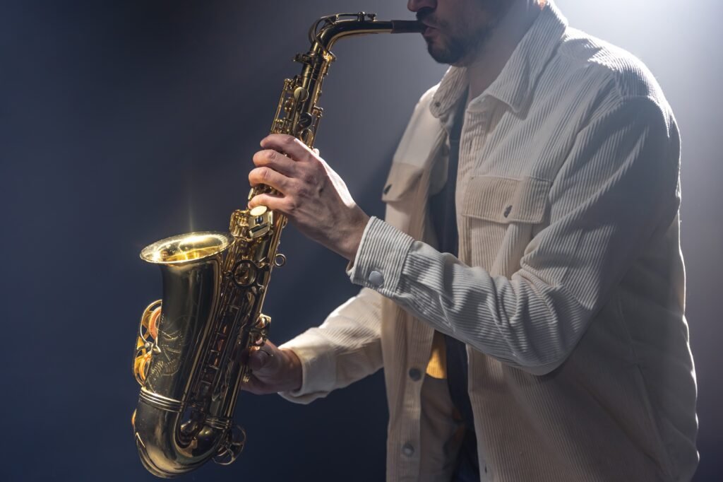 Male musician on stage plays the saxophone dark with smoke.